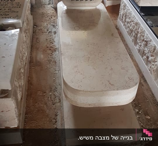 מצבת שיש בהיר מעוצבת עם פלטה עליונה מעוגלת וכיתוב חרוט